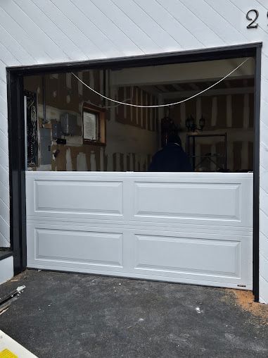 A white garage door is open to a garage.
