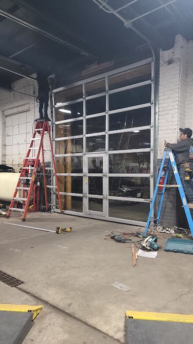 A man is working on a garage door in a garage.