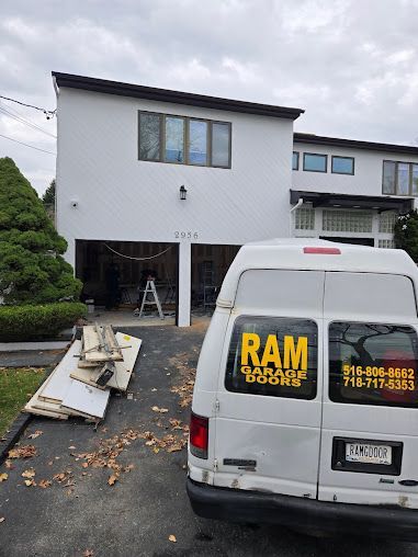 A white van is parked in front of a white house.