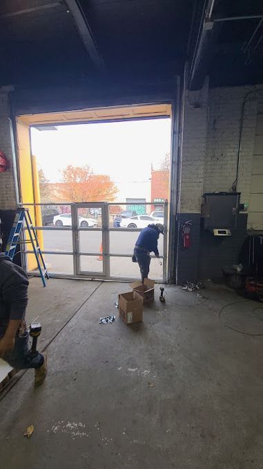 A man is working on a garage door in a garage.
