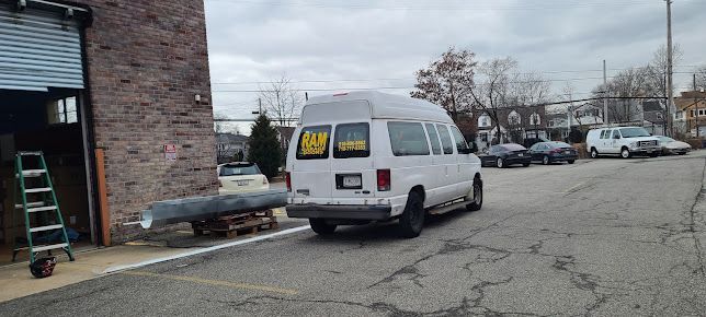A white van is parked in a parking lot in front of a building.
