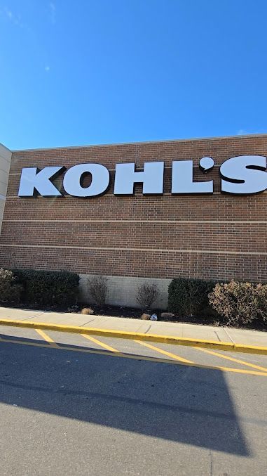 The front of a kohl 's store with a blue sky in the background.