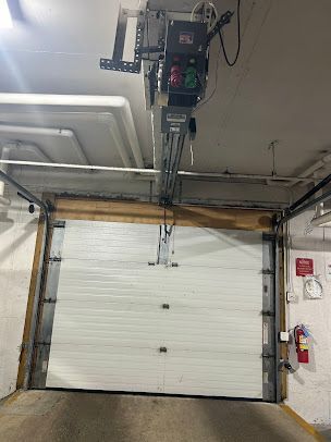 A garage door with a garage door opener hanging from the ceiling.