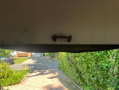 A view of a driveway from the inside of a garage door.
