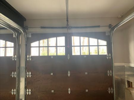 A garage door with a motor hanging from the ceiling.