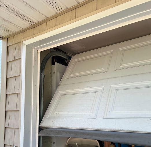 A white garage door is open on a house.