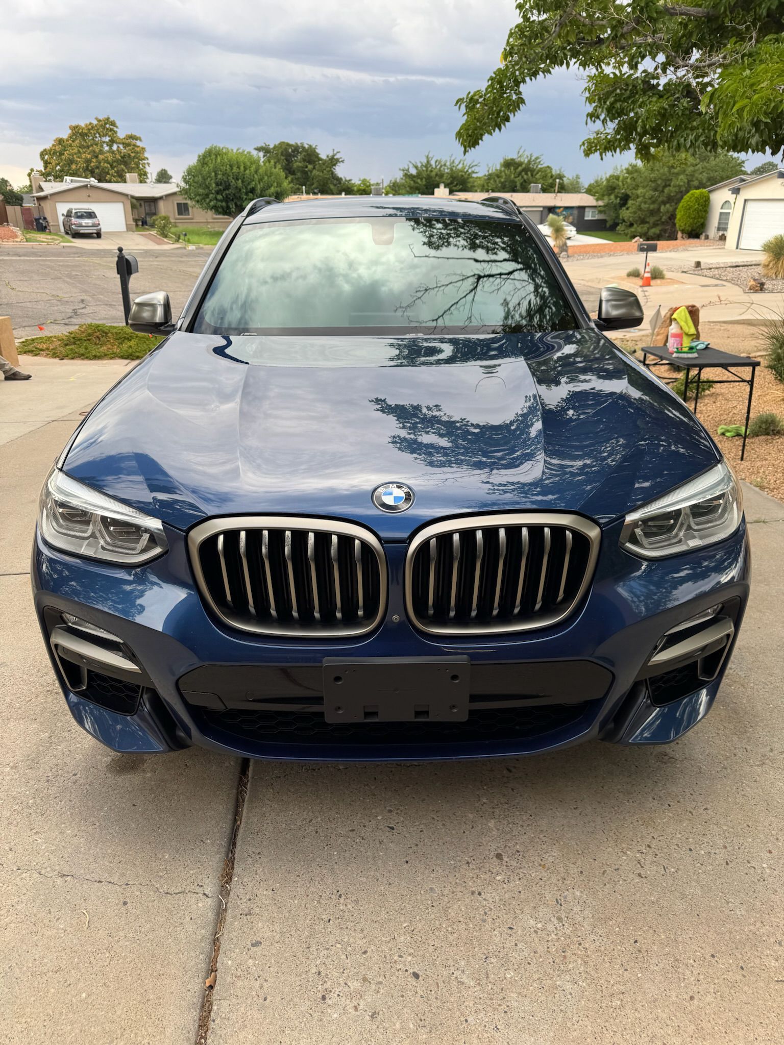 Blue BMW X3 parked on a driveway. Front view.