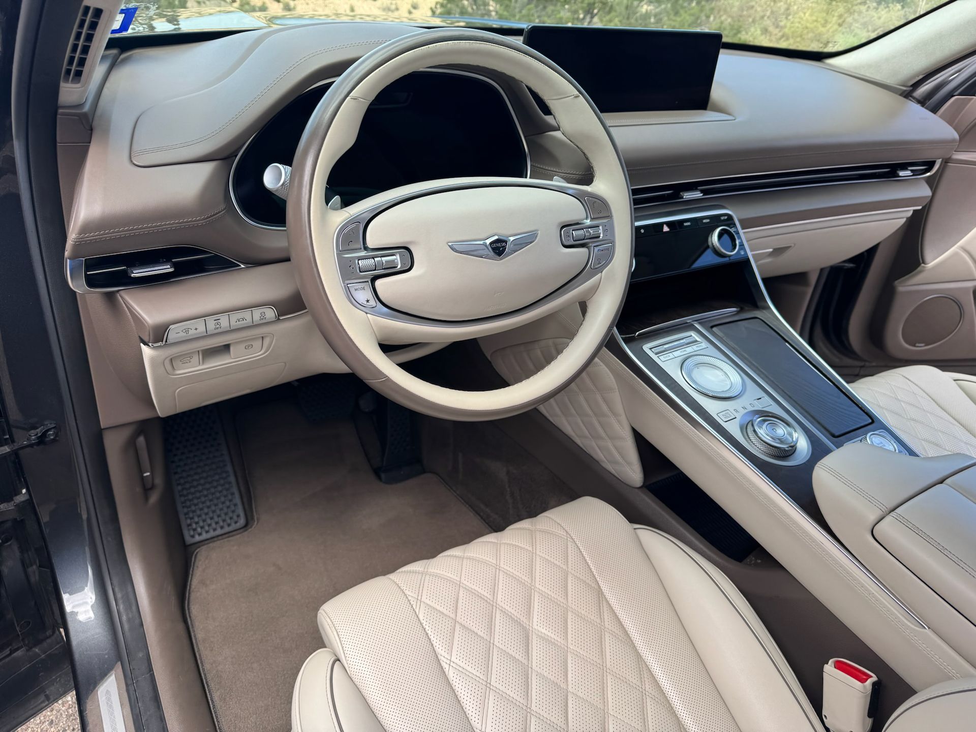 Tan Genesis car interior with quilted leather seats, steering wheel, and dashboard.
