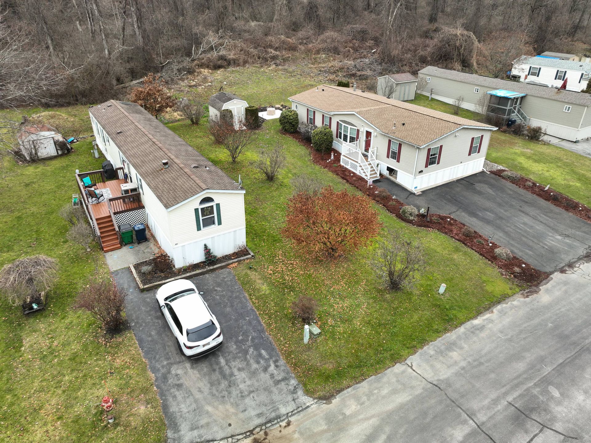 An aerial view of a mobile home park with a car parked in the driveway.