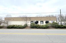 A large building is sitting on the side of a road next to a road.