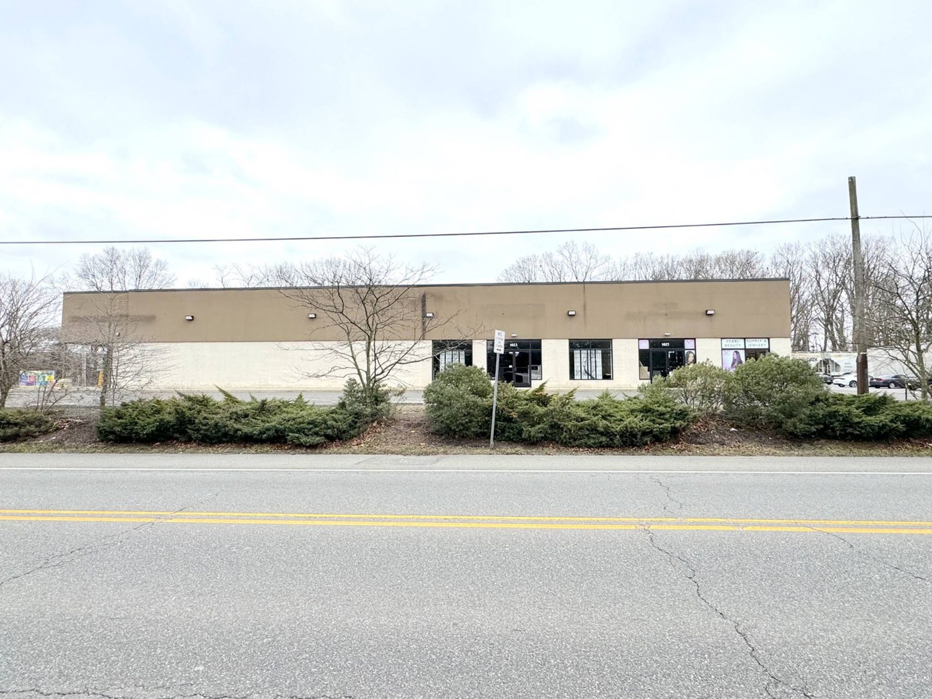 A large building is sitting on the side of a road next to a road.