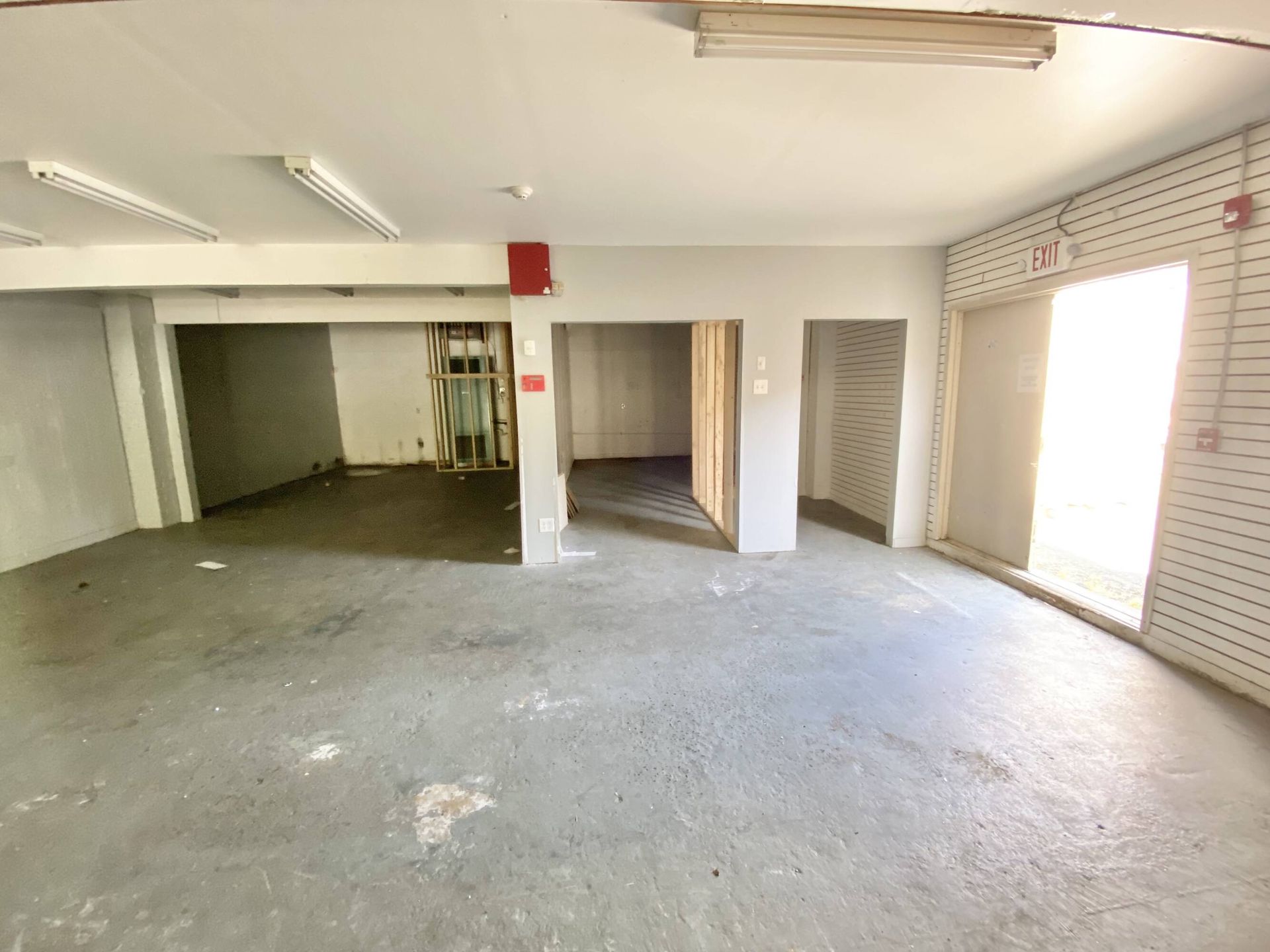 A large empty room with a lot of windows and doors