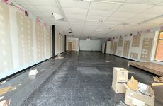 A large empty room with boxes on the floor and a ceiling.