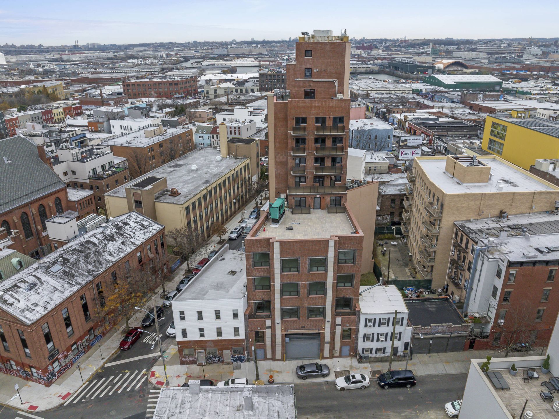 An aerial view of a city with a large brick building in the middle.