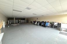 A large empty office with a lot of desks and chairs.