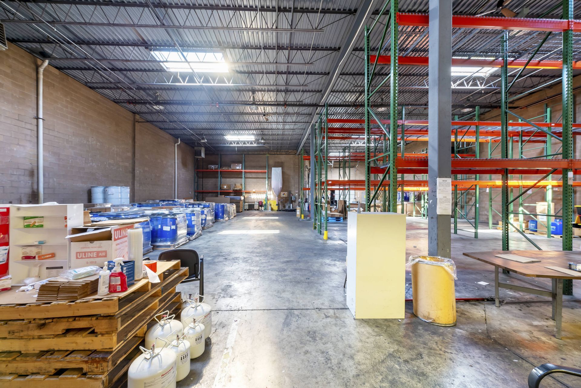 A large warehouse filled with lots of shelves and pallets.