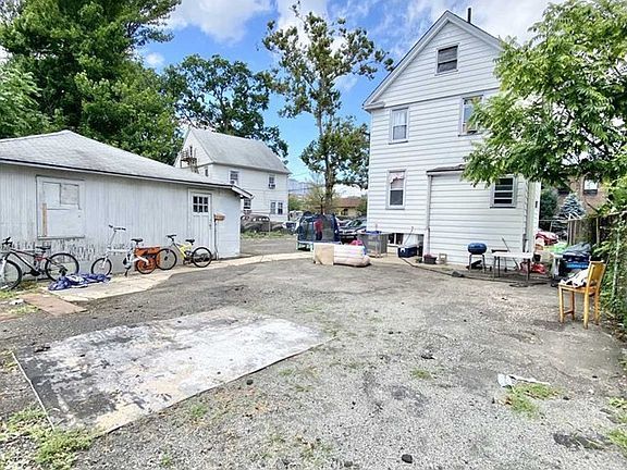A lot of bikes are parked in the backyard of a house.