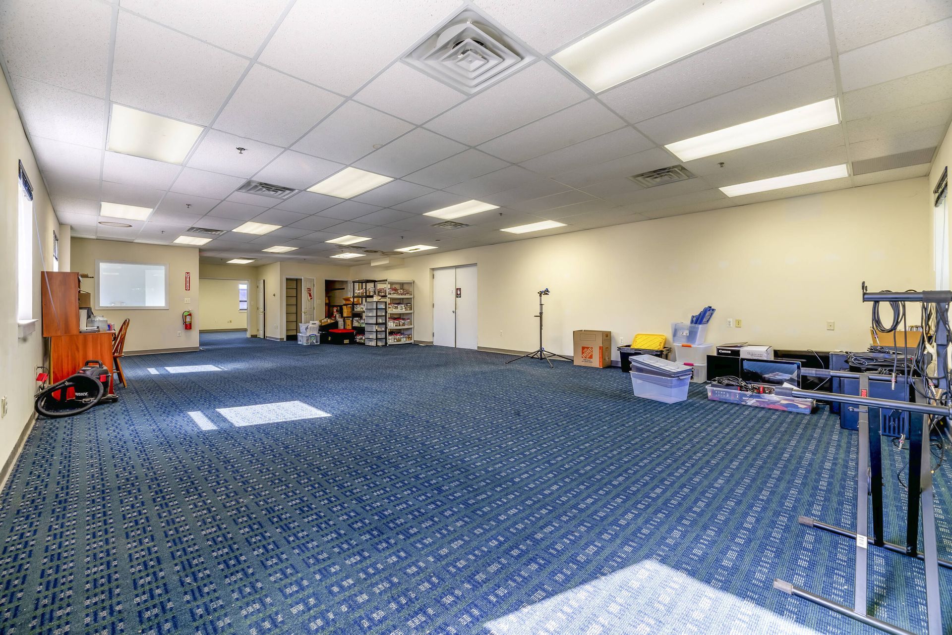 A large empty room with a blue carpet and white walls.