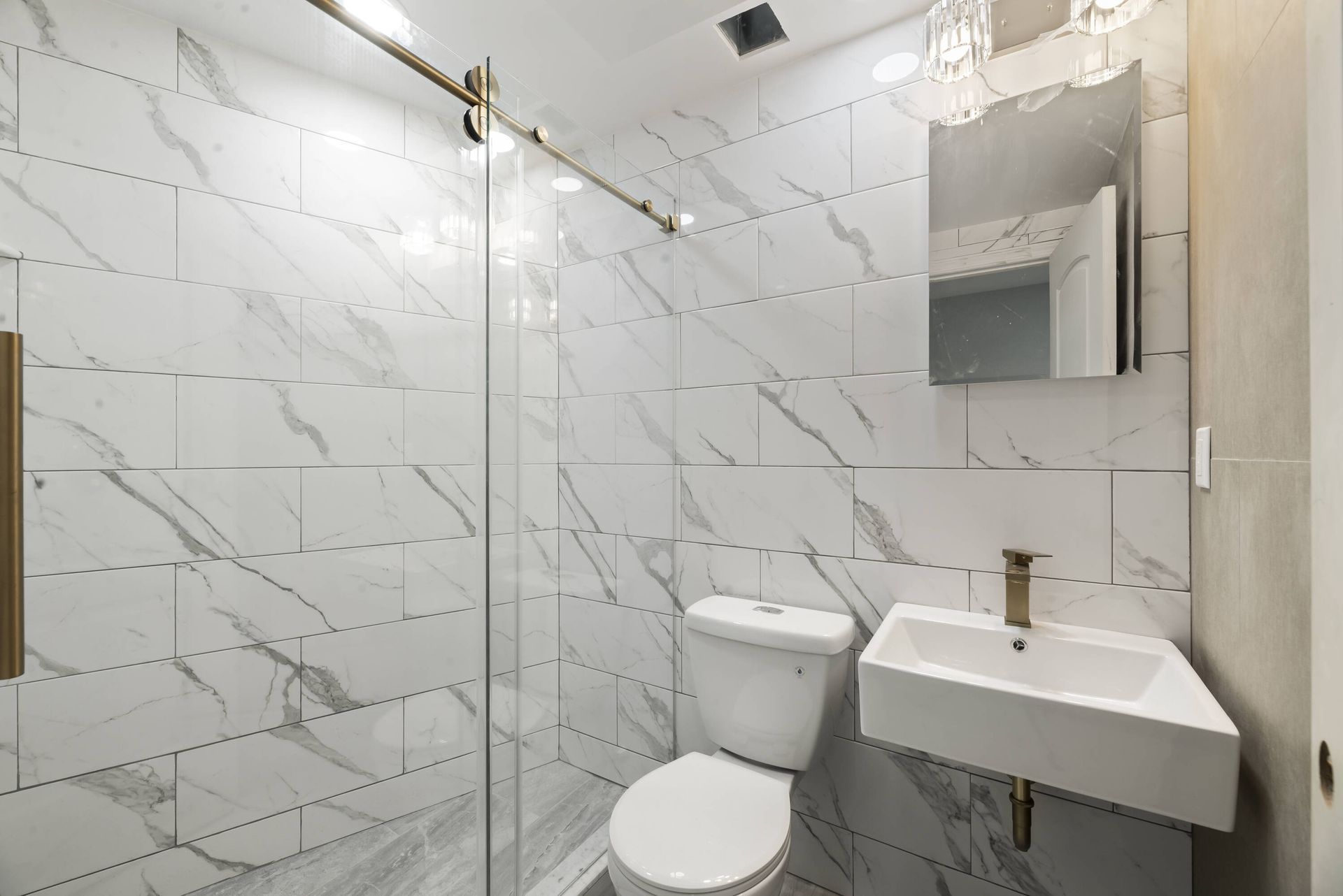 A bathroom with a toilet , sink and shower.