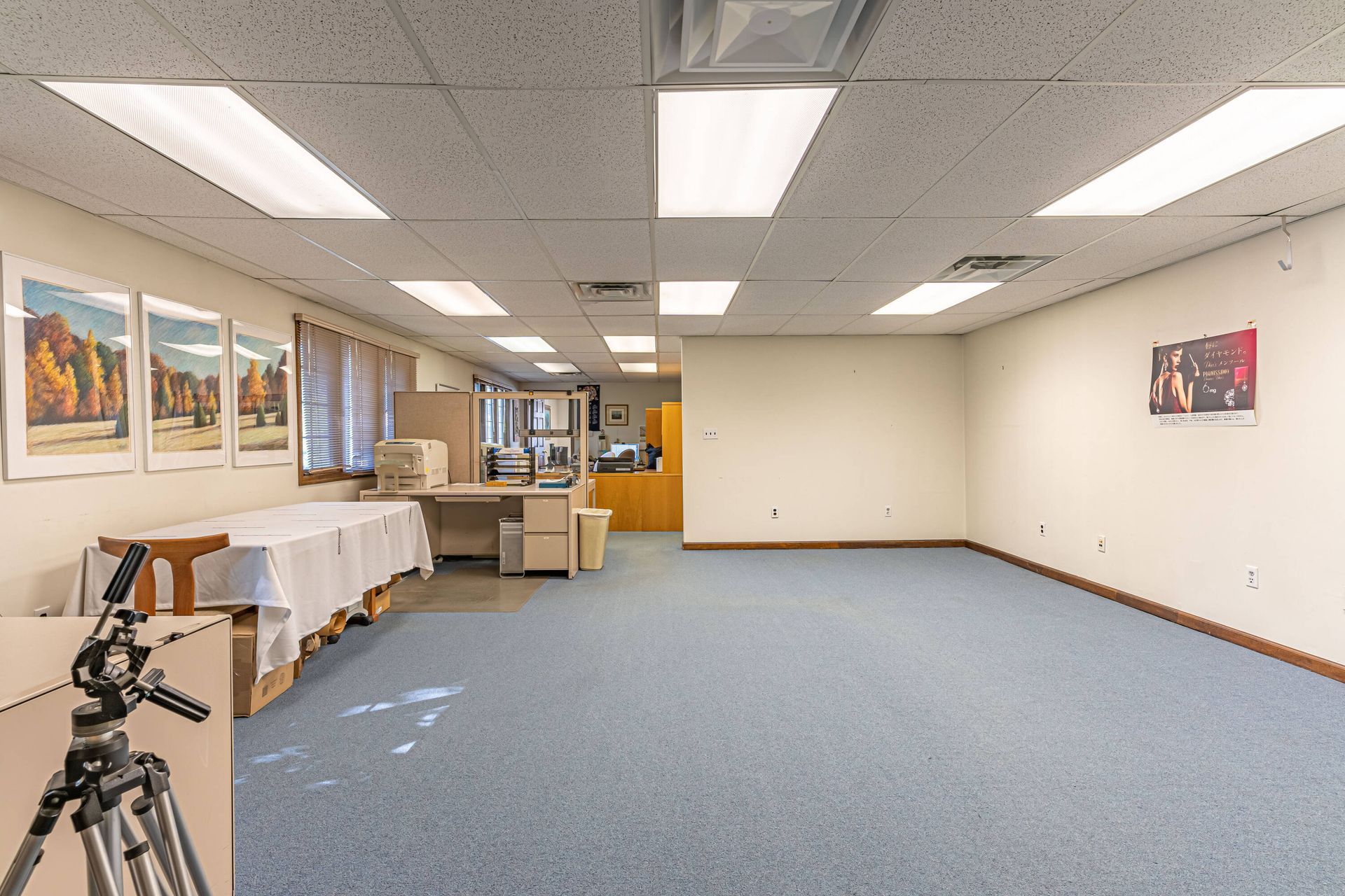 An empty room with a table and a tripod in it