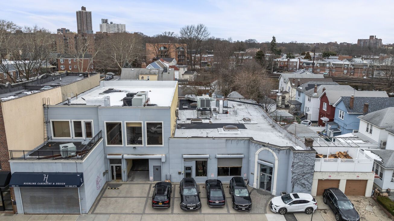An aerial view of a building with cars parked in front of it.