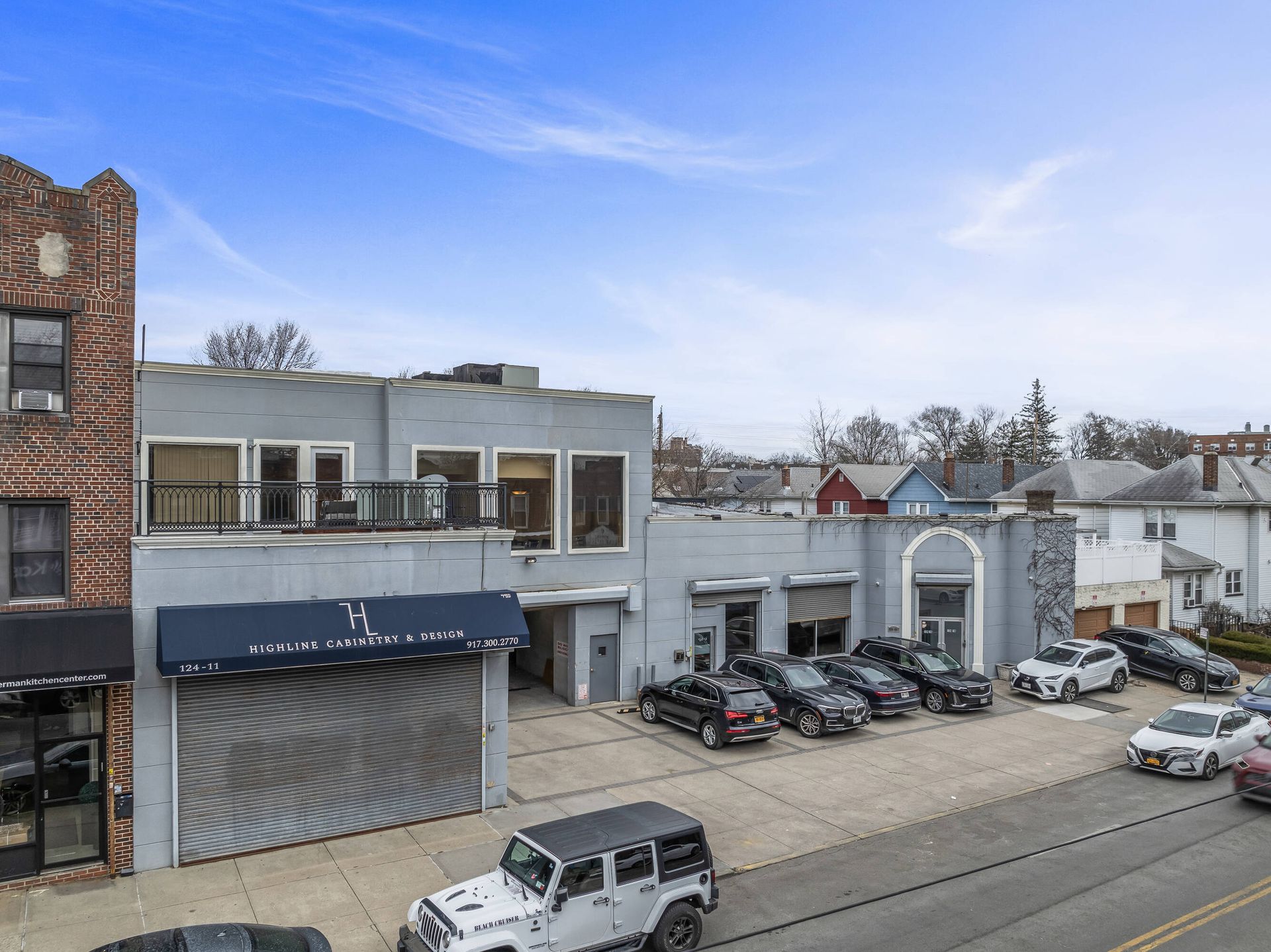 A jeep is parked in front of a building with cars parked in front of it.