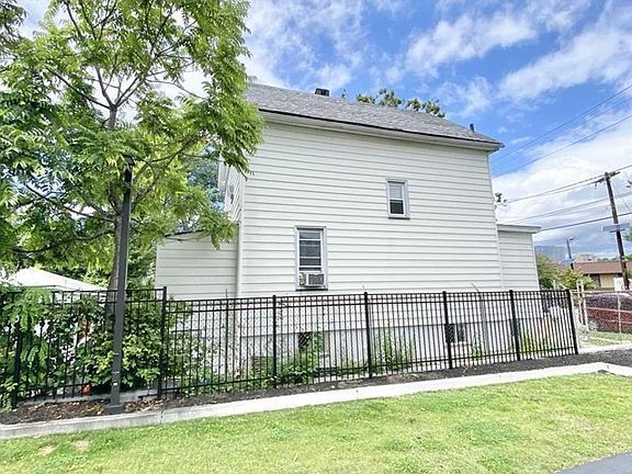 A white house with a black fence in front of it.