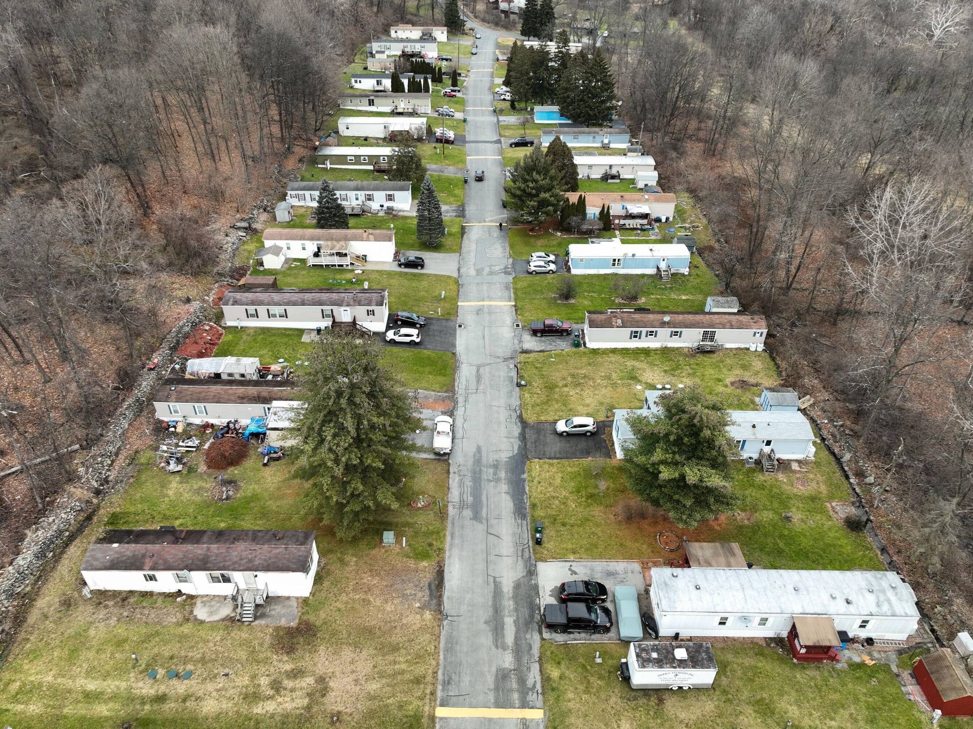 An aerial view of a mobile home park with a road going through it.