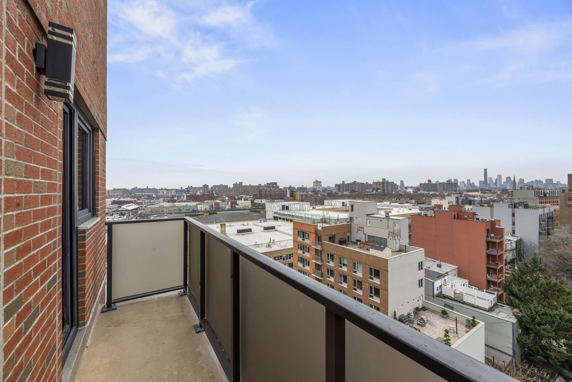 A balcony with a view of a city from a brick building