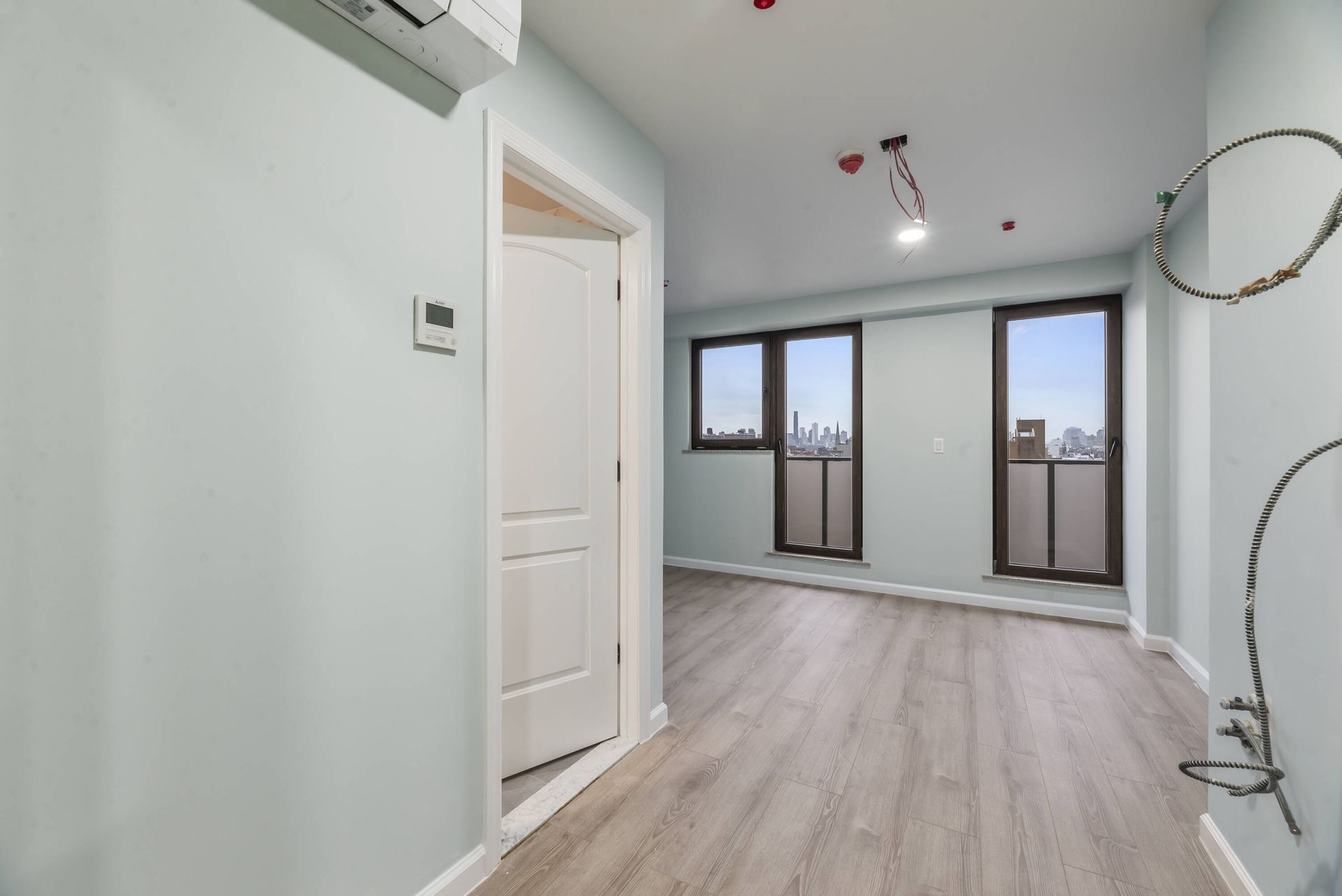 An empty room with hardwood floors and a window