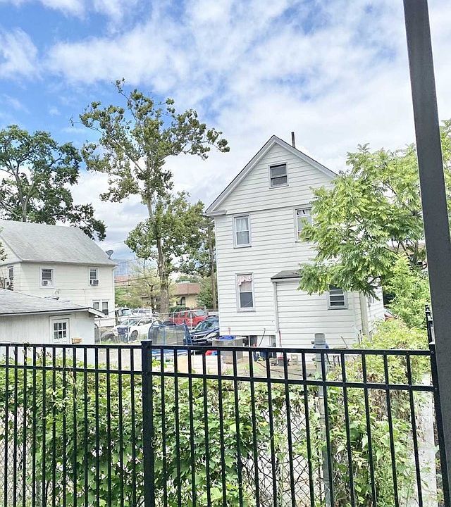 A white house with a black fence in front of it