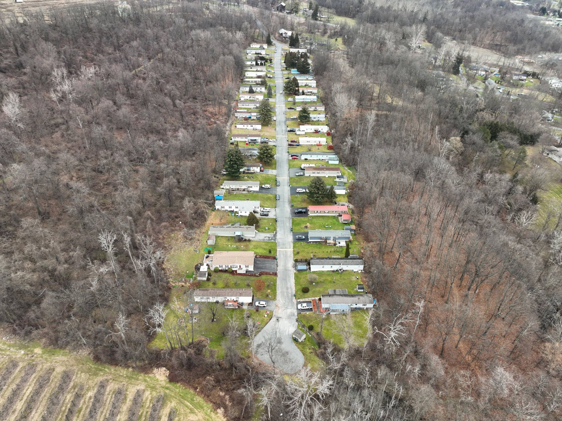 An aerial view of a mobile home park surrounded by trees.