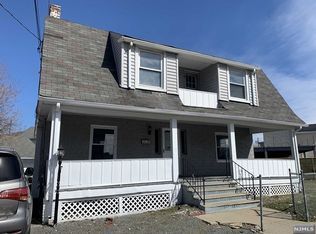 A large house with a car parked in front of it.
