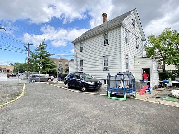A white house with a car parked in front of it.
