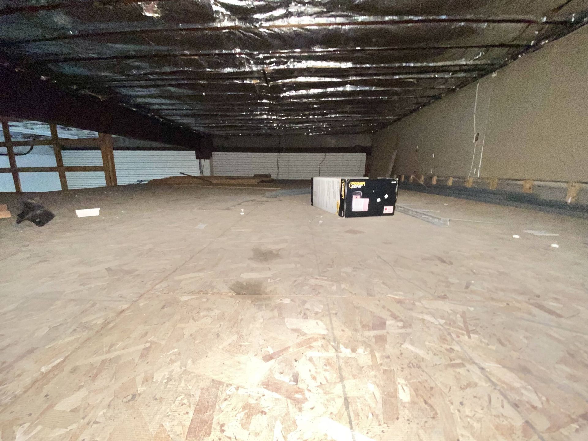 A large empty room with a box on the floor.
