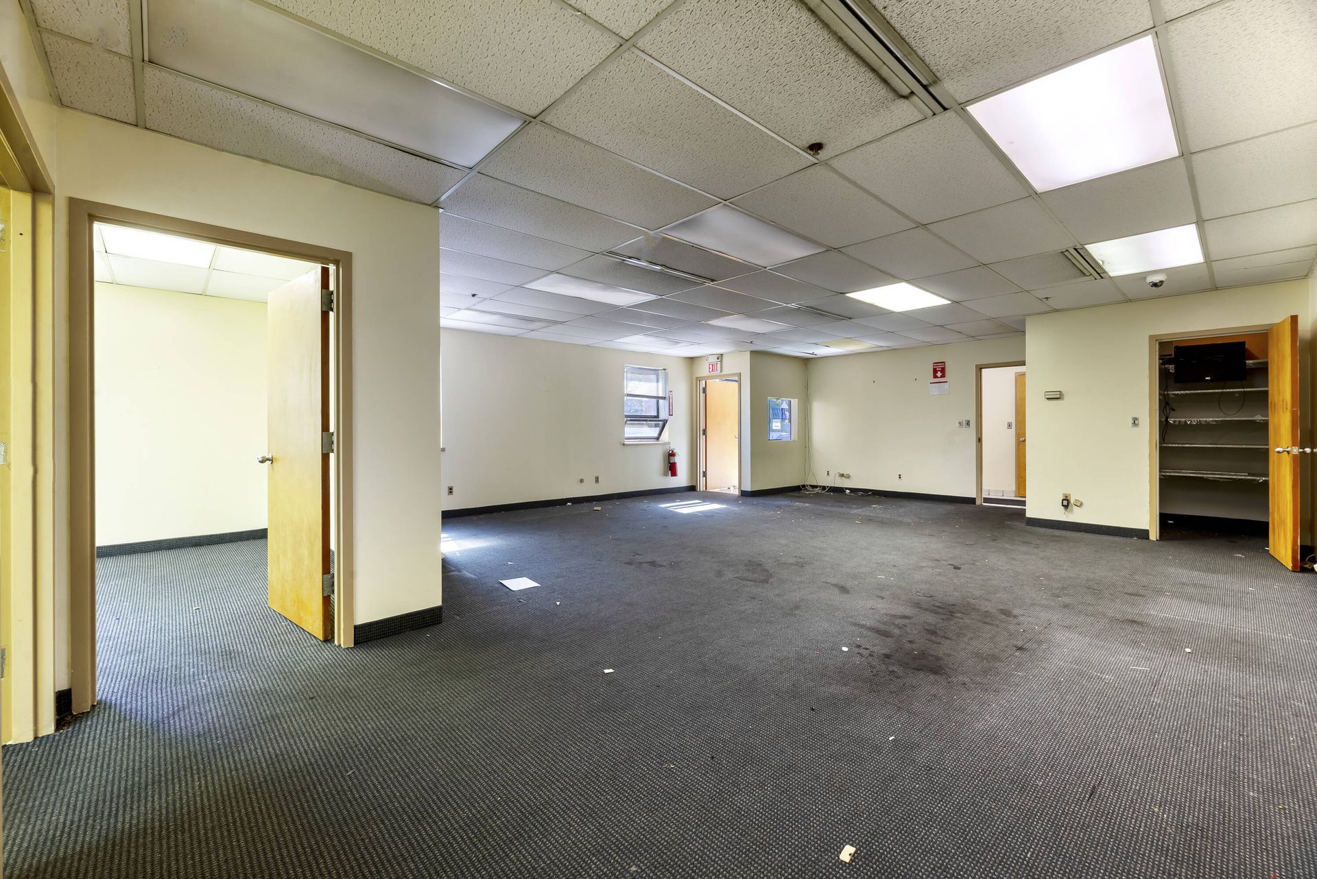 An empty room with a carpeted floor and white walls