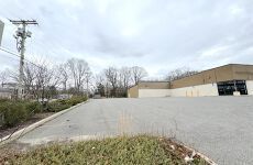 A large empty parking lot with a building in the background.