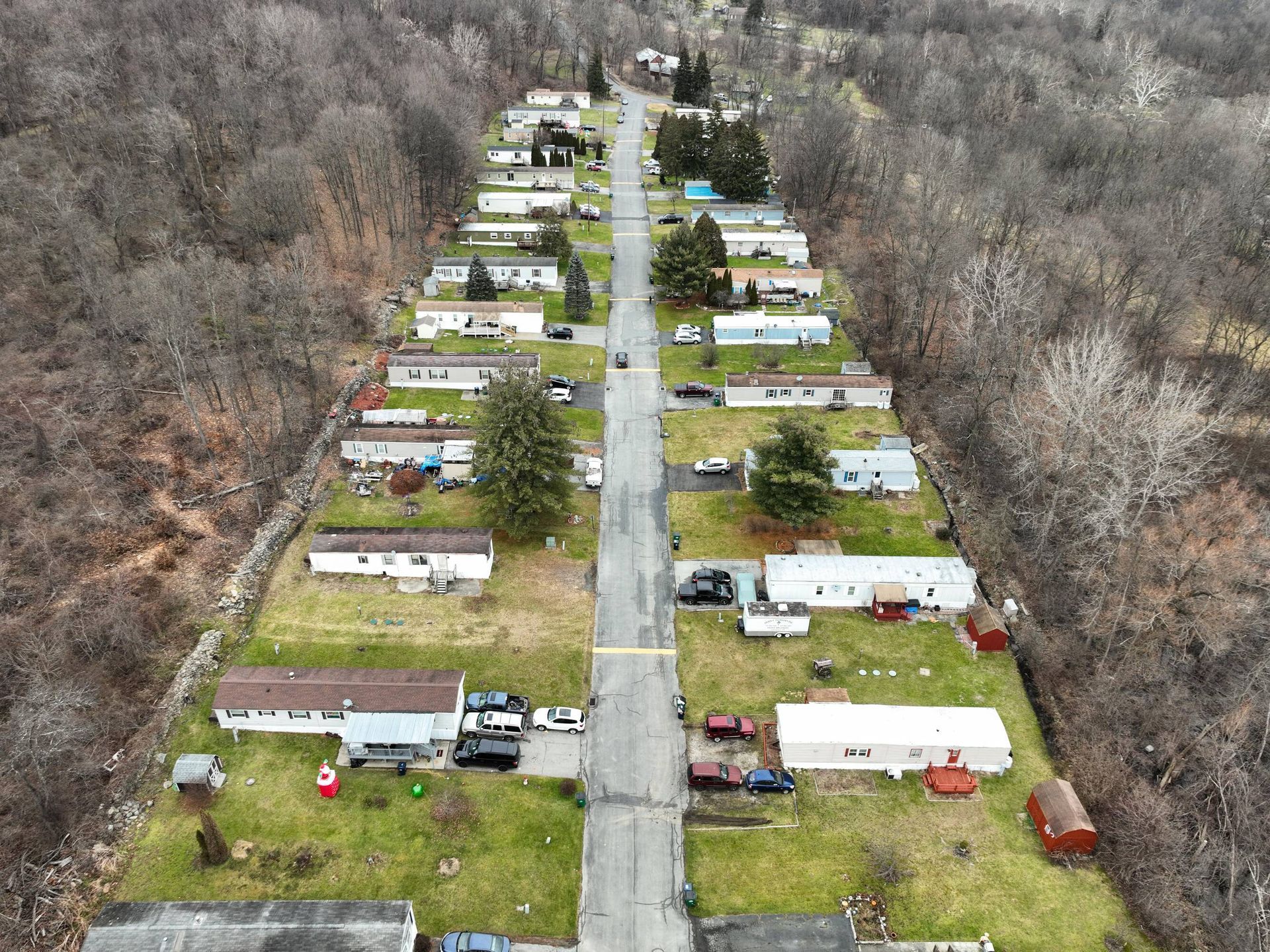 An aerial view of a mobile home park in the woods