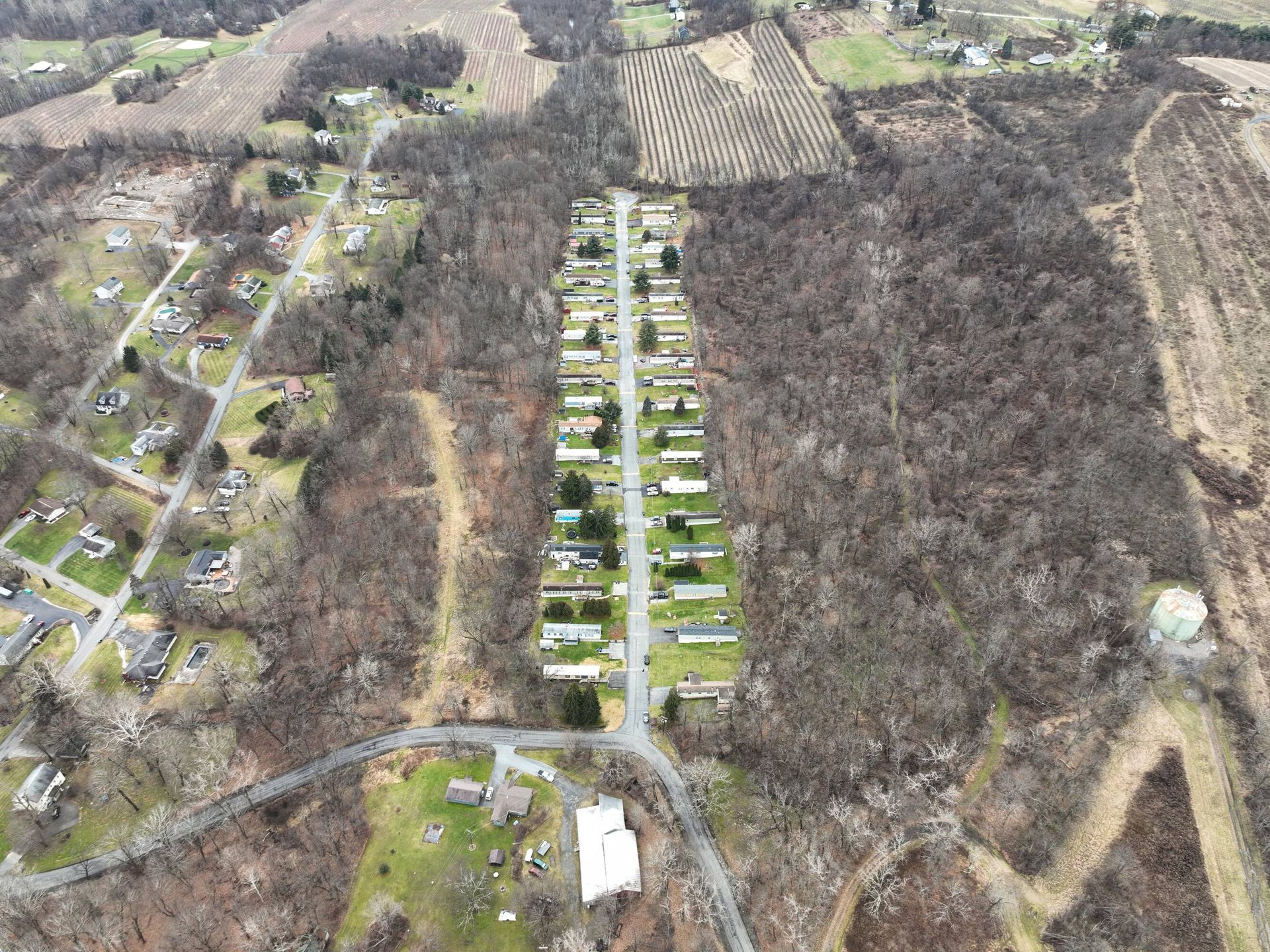 An aerial view of a mobile home park surrounded by trees and fields.