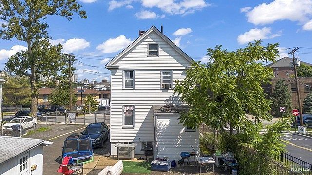 An aerial view of a white house with cars parked in front of it.