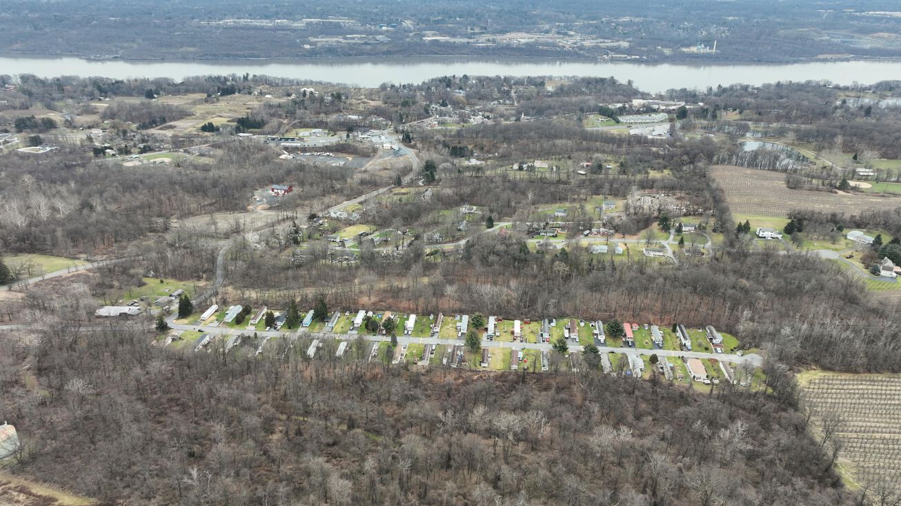 An aerial view of a residential area with a river in the background.
