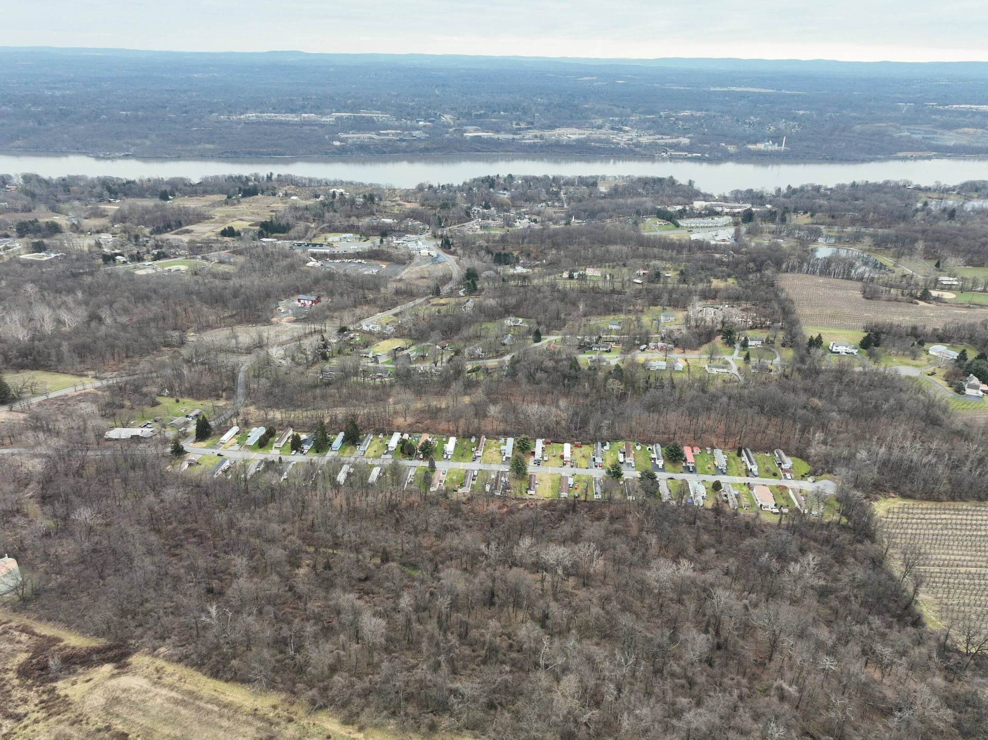An aerial view of a residential area with a river in the background.