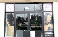 The front door of a hair salon with a picture of a woman on the window.