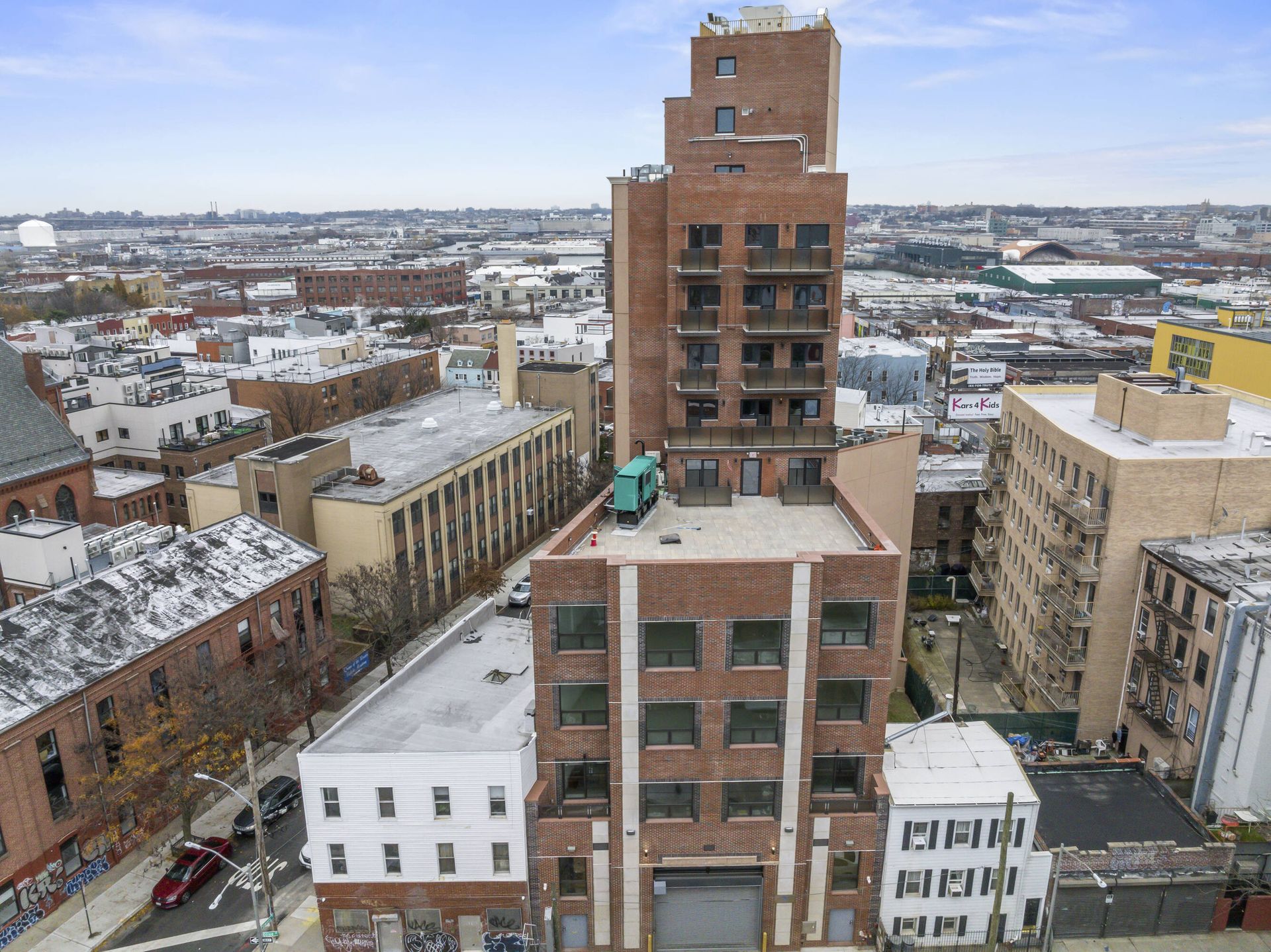An aerial view of a city with a brick building in the middle