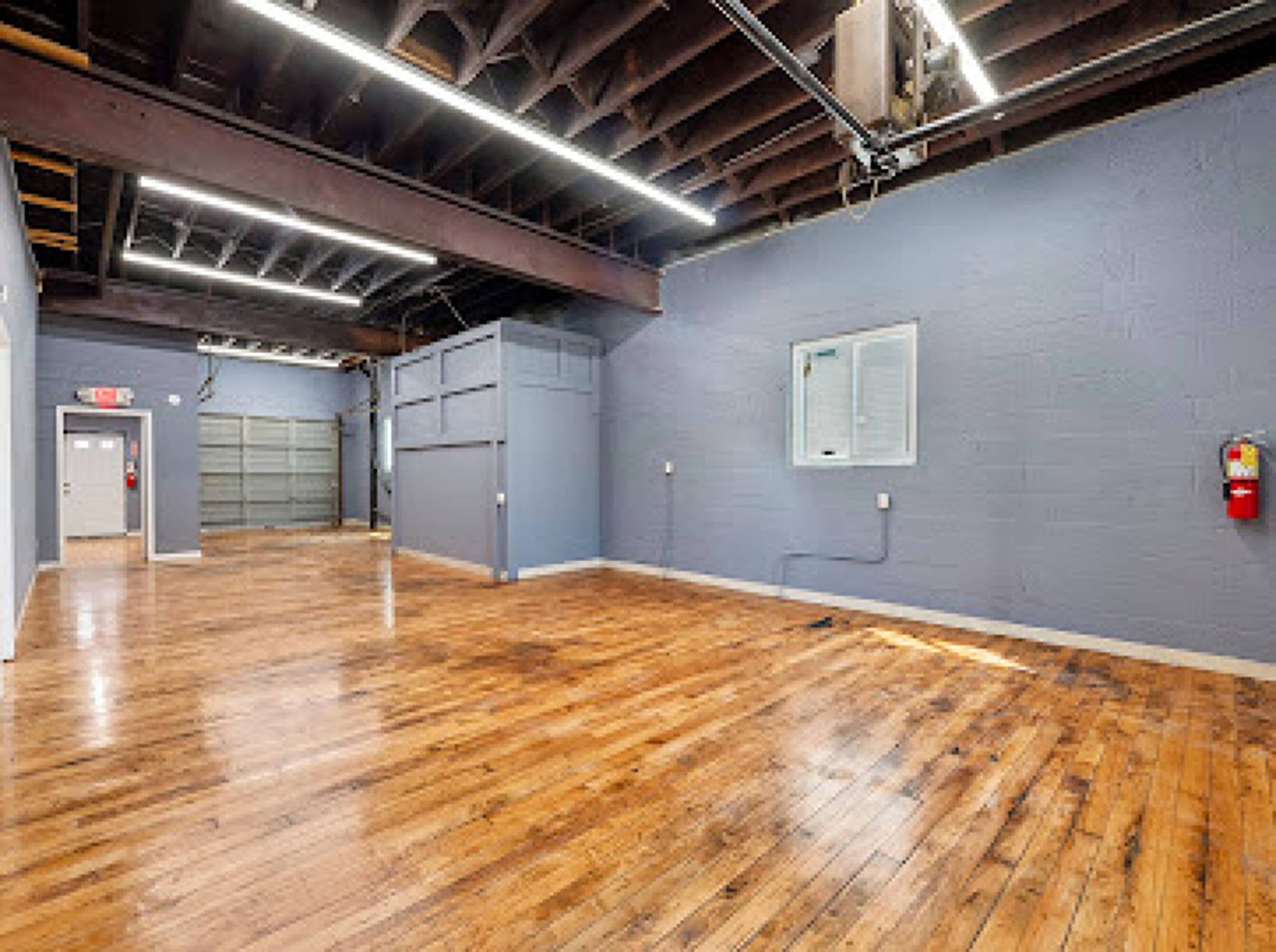 A large empty room with hardwood floors and blue walls.