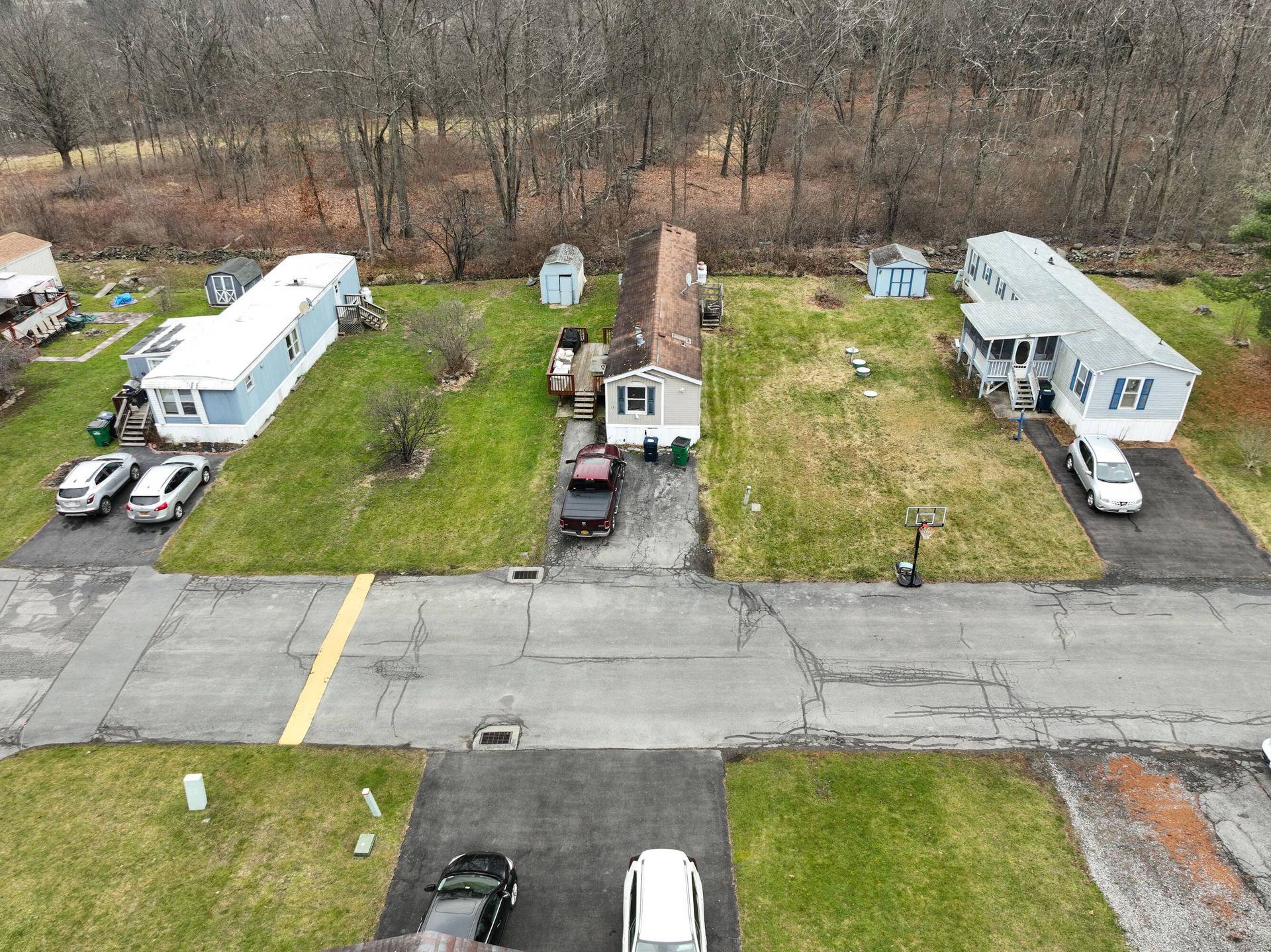 An aerial view of a mobile home park with cars parked on the side of the road.