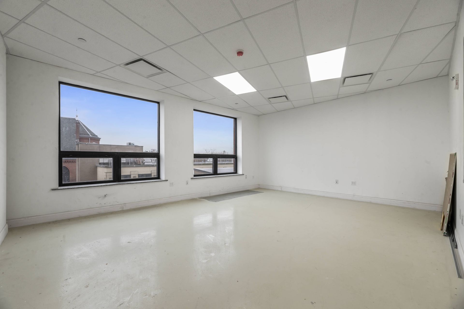 An empty room with a lot of windows and a ceiling light.