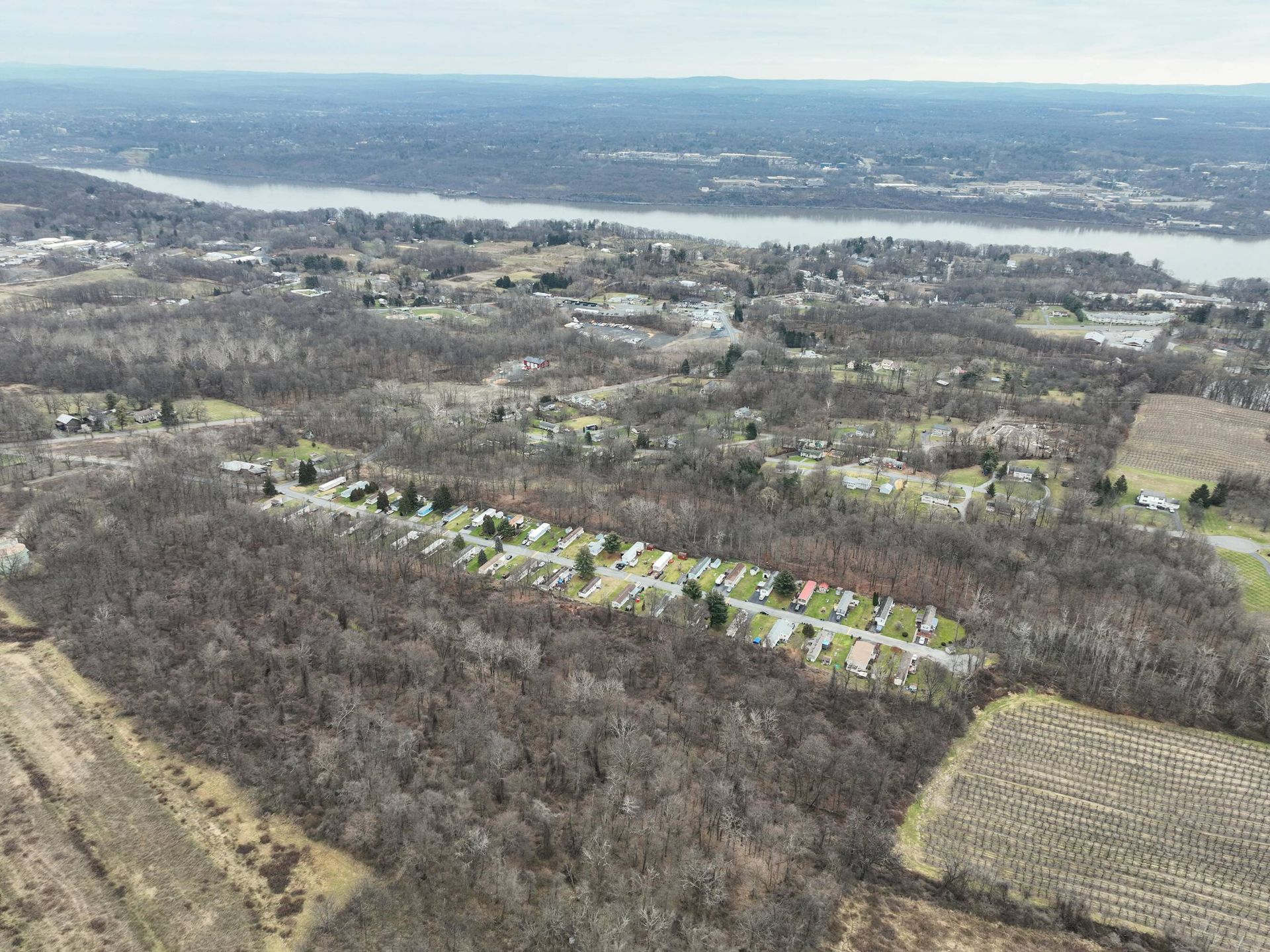 An aerial view of a residential area with a river in the background.
