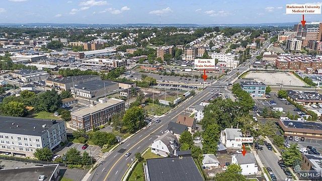 An aerial view of a city with a red arrow pointing to a building.