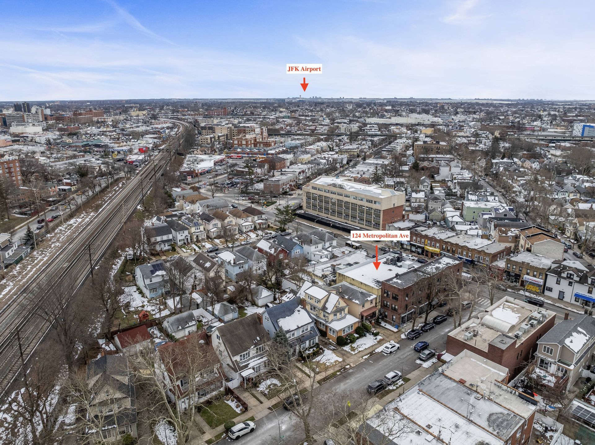 An aerial view of a city with a lot of buildings and a train track.